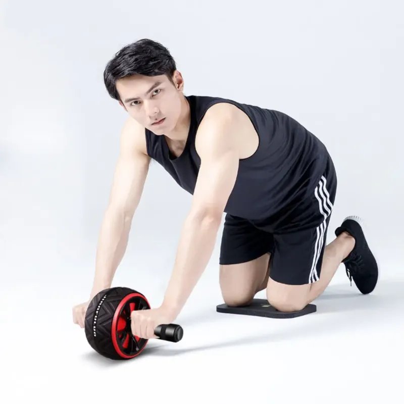 Uomo che usa ruota addominale fitness per esercizi core