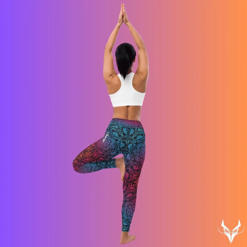 Donna in posa di yoga, con braccia alzate e gambe incrociate, indossa leggings mandala di yoginess.